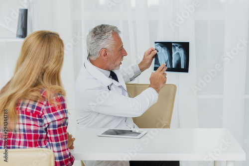 Doctor pointing at x-ray with patient
