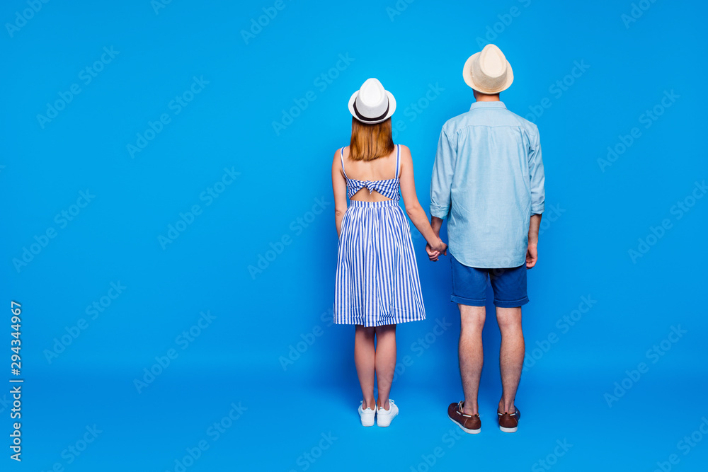 Rear back behind full length body size view of his he her she two nice attractive people holding hands spending vacation summertime day isolated on bright vivid shine vibrant blue color background Rear back behind full length body size view of his he her she two nice attractive people holding hands spending vacation summertime day isolated on bright vivid shine vibrant blue color background