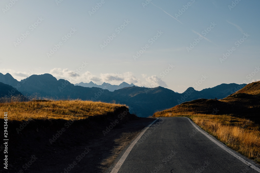 Beautiful landscape with road and mountain range silhouette in the Alps during sunset