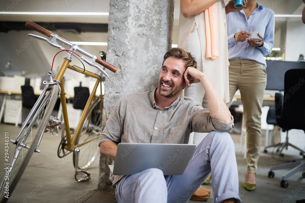 Obraz premium Happy coworker businessman carrying bicycle in modern office