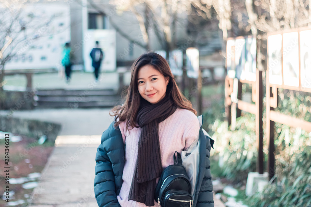 Beautiful young Asian woman in her winter jacket, traveler concept.