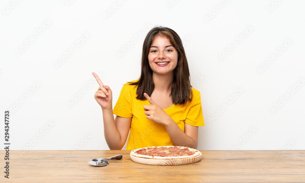 Caucasian girl with a pizza pointing finger to the side