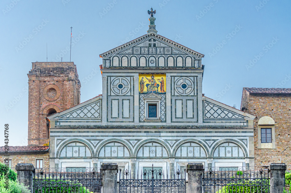 Bellissima facciata medievale della chiesa di San Miniato al Monte di Firenze, Toscana, Italia, vista dalla scalinata dal basso, contro il cielo sereno e luminoso del mattino italiano