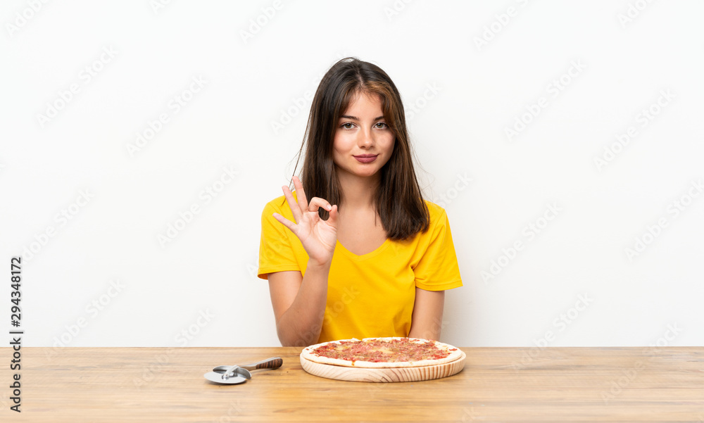 Caucasian girl with a pizza showing an ok sign with fingers Caucasian girl with a pizza showing an ok sign with fingers