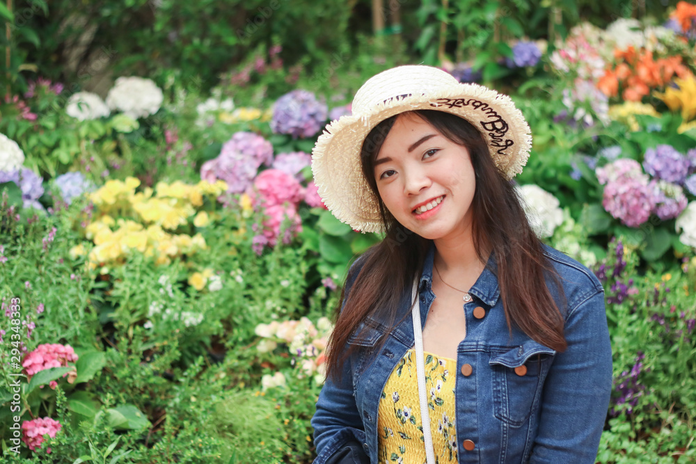 Close up of young Asian woman with blur flower background.
