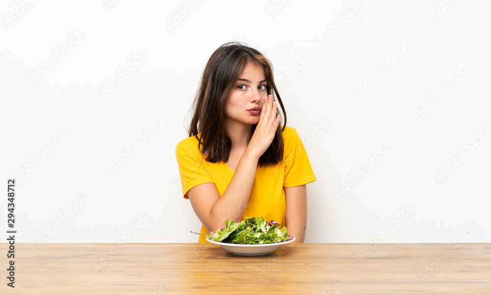 Caucasian girl with salad whispering something Caucasian girl with salad whispering something