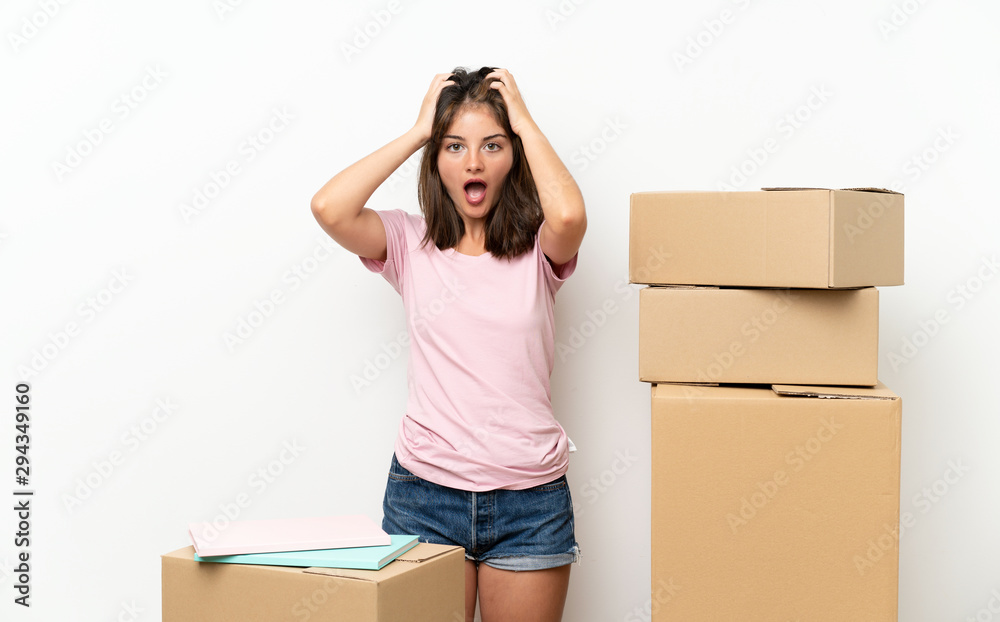 Young girl moving in new home among boxes with surprise facial expression Young girl moving in new home among boxes with surprise facial expression