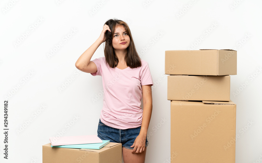 Young girl moving in new home among boxes having doubts and with confuse face expression Young girl moving in new home among boxes having doubts and with confuse face expression