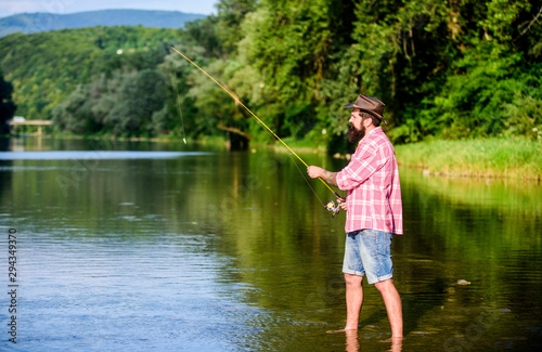 big game fishing. relax on nature. mature bearded man with fish on rod. successful fisherman in lake water. hipster fishing with spoon-bait. fly fish hobby. Summer activity. It is a big fish