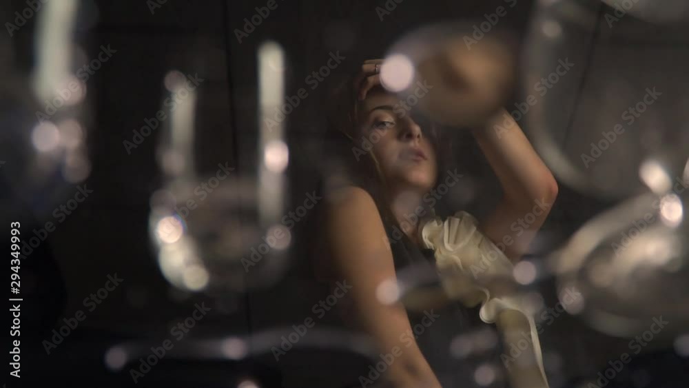 Woman in black dress is posing and touching her hair Woman in black dress is posing and touching her hair