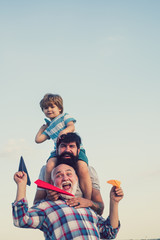 Men generation. Kids playing with simple paper planes on sunny day. Father giving son ride on back in park. Enjoy family together. Generation of people and stages of growing up.