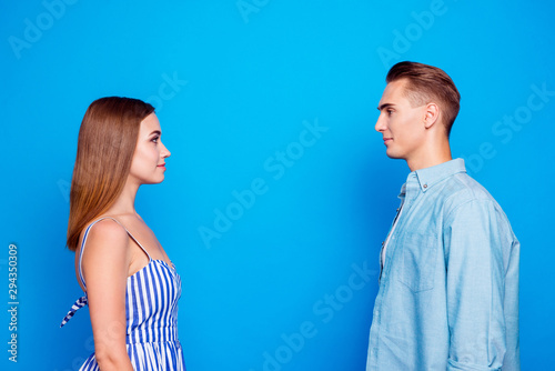 Profile side view portrait of her she his he two nice attractive charming lovely content calm people looking at each other trust care isolated over bright vivid shine vibrant blue color background
