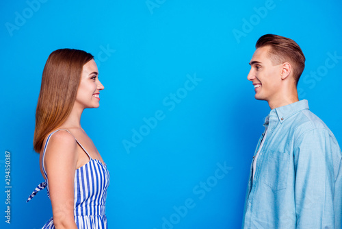 Profile side view portrait of her she his he two nice attractive charming lovely content cheerful cheery people looking at each other isolated over bright vivid shine vibrant blue color background
