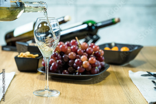 Pouring wine into glass and food background