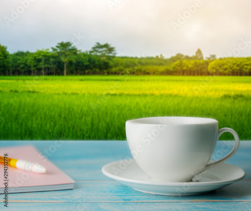 A cup of coffee with rice field rural with colorful of sky in morning light