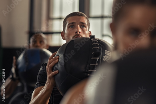 Obraz na plátně Fitness man doing squat with heavy ball