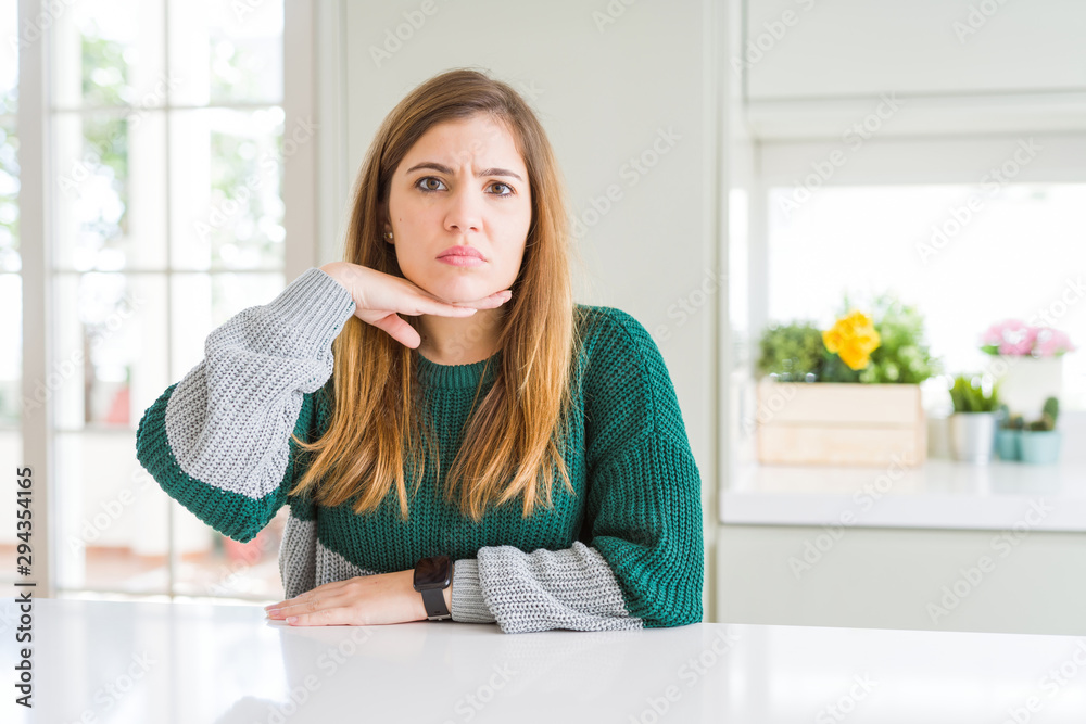 Young beautiful plus size woman wearing casual striped sweater cutting throat with hand as knife, threaten aggression with furious violence Young beautiful plus size woman wearing casual striped sweater cutting throat with hand as knife, threaten aggression with furious violence