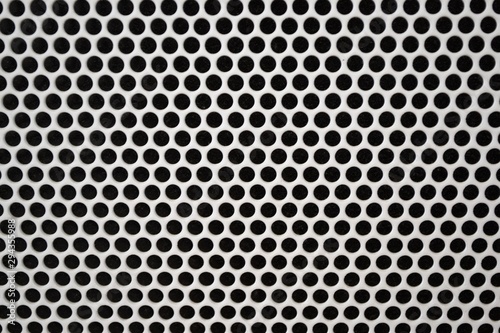 Metal grid background texture. Holes in the radiator close-up.