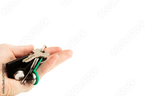 Hand holds a bunch of keys with a chip on a white background