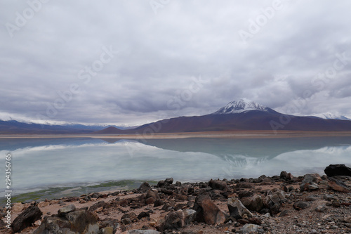 View of the Laguna Blanca in the desert landscape of the Andean highlands of Bolivia with the peaks of the snow-capped volcanoes of the Andes