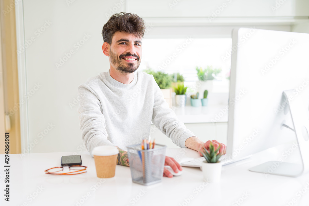Young handsome man working using computer, smiling concentrated on internet Young handsome man working using computer, smiling concentrated on internet