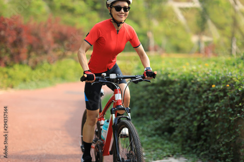 Woman cyclist riding mountain bike outdoors