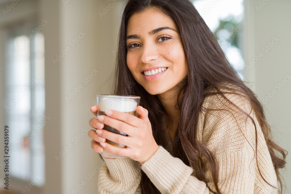Beautiful young girl drinking a cup of coffee at home and smiling Beautiful young girl drinking a cup of coffee at home and smiling