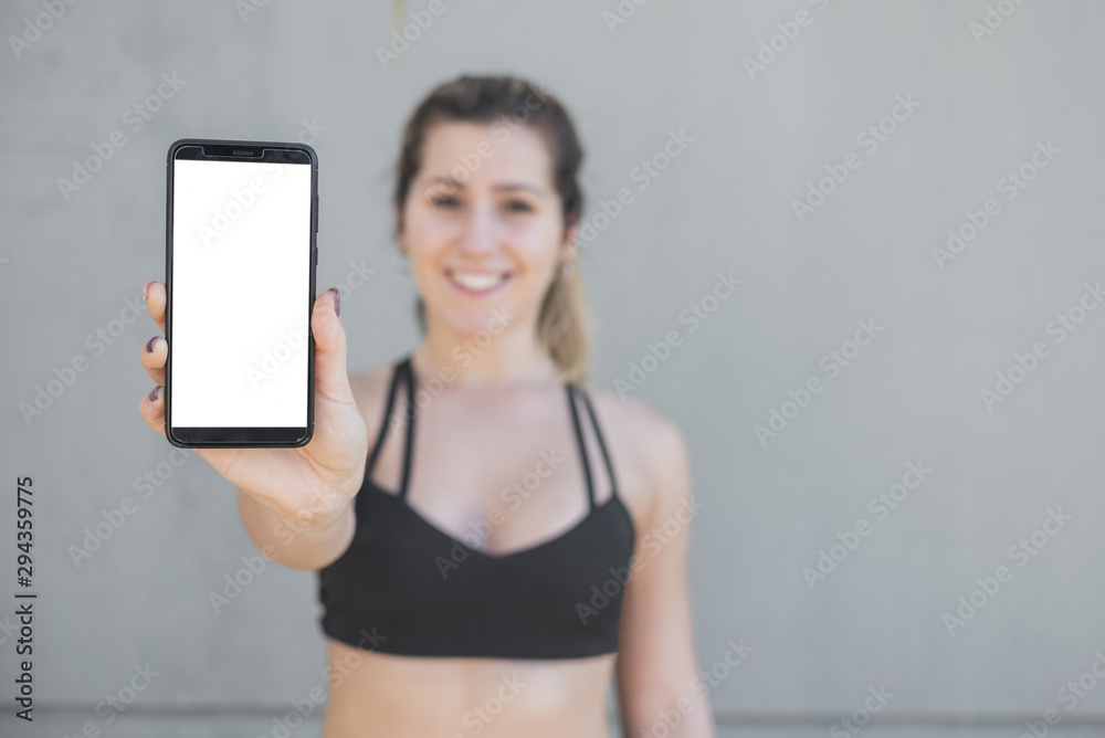 Front view fit girl holding phone with mock-up Front view fit girl holding phone with mock-up
