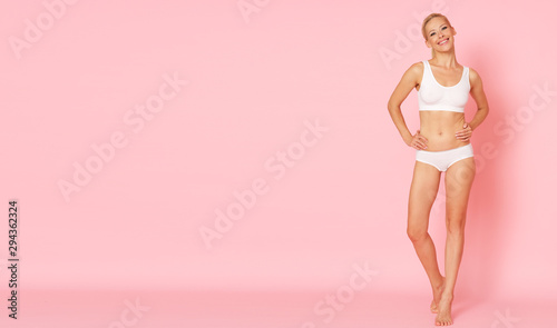 Model with perfect body posing on pink background.