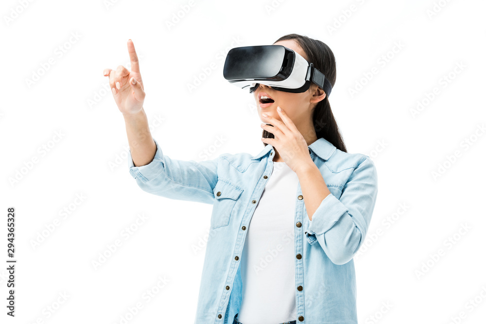 shocked woman in denim shirt with virtual reality headset pointing with finger isolated on white shocked woman in denim shirt with virtual reality headset pointing with finger isolated on white