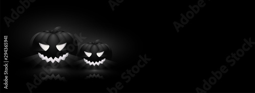 Spooky, illuminated jack-o-lanterns on black background with space for your text. Website header design for Halloween celebration.