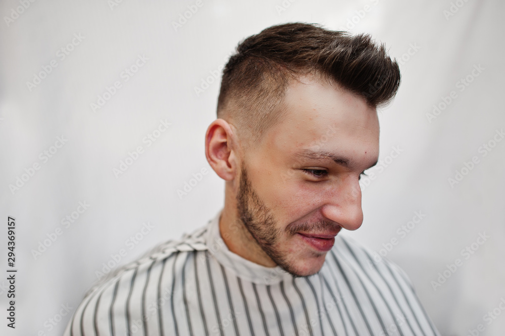 Fototapeta premium Close up head of young bearded man getting haircut at barbershop. Barber soul.