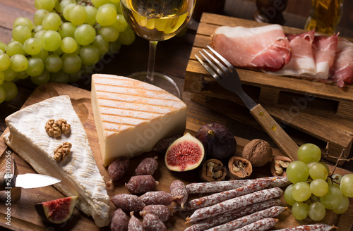 cheese,wine,sausage, ham on rustic wooden background photo