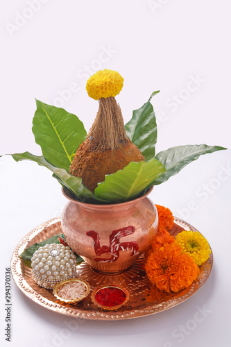 Copper Kalash with coconut ,  Red accounting note book, leaf and floral decoration on a white background. essential in hindu puja. photo