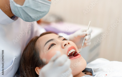 Tablou canvas Woman having dental teeth examined dentist check-up via excavator in Clinic