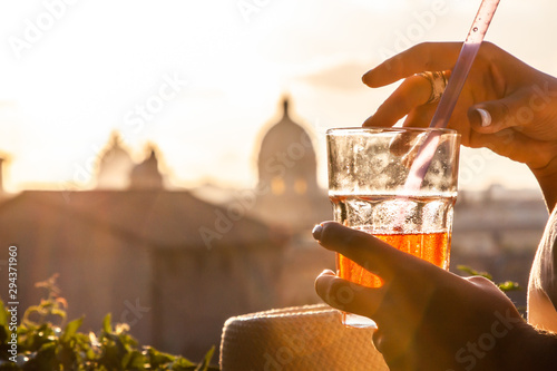 Photography Young woman tourist fashion white dress with spritz cocktail in front of panoramic view of Rome cityscape from campidoglio terrace at sunset