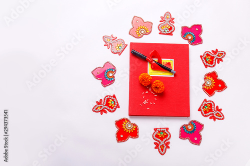  Red accounting note book , diya, and flower rangoli on white background photo