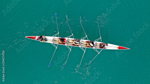 Aerial drone photo of team of Athletes rowing in sport canoe in tropical exotic lake