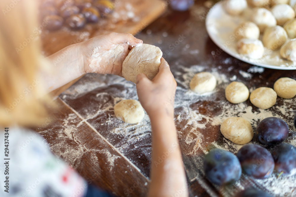 Little girl preparing plum dumplings at home Little girl preparing plum dumplings at home