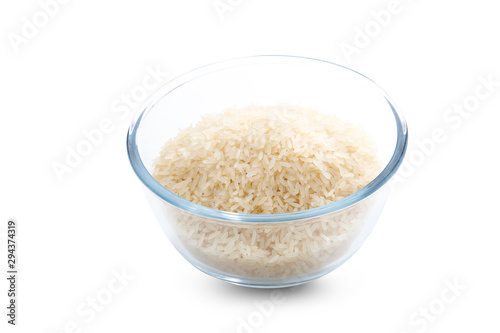 Bol de cristal de arroz crudo sobre fondo blanco, vista cenital. Glass bowl of raw rice on white background, overhead view.