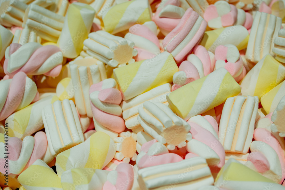 Close up of Marshmallows - white with yellow and pink colors in the form of spirals, flowers and stripes. Sweet background Close up of Marshmallows - white with yellow and pink colors in the form of spirals, flowers and stripes. Sweet background