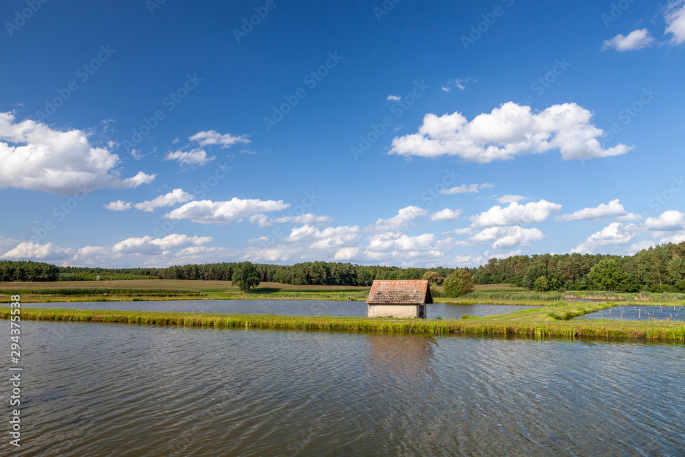 Weite Landschaft mit großen Teichen und kleiner Hütte Weite Landschaft mit großen Teichen und kleiner Hütte