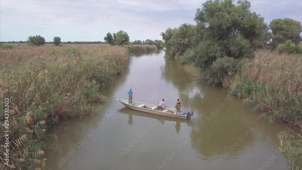 Anglers fishing from the boat floating on the river. Astrakhan region, Russia Anglers fishing from the boat floating on the river. Astrakhan region, Russia