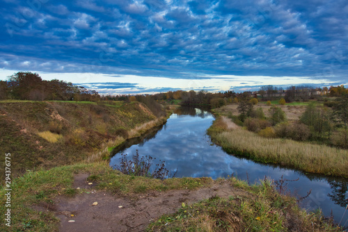 Dramatic sky reflected in a tranquil winding river