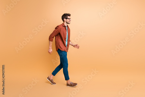 Full length body size profile side view of his he nice attractive trendy cheerful cheery brunette guy business assistant agent broker walking isolated over beige color pastel background © deagreez