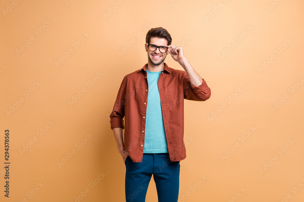 Portrait of his he nice attractive cheerful cheery experienced brunet guy skilled expert touching specs isolated over beige color pastel background Portrait of his he nice attractive cheerful cheery experienced brunet guy skilled expert touching specs isolated over beige color pastel background