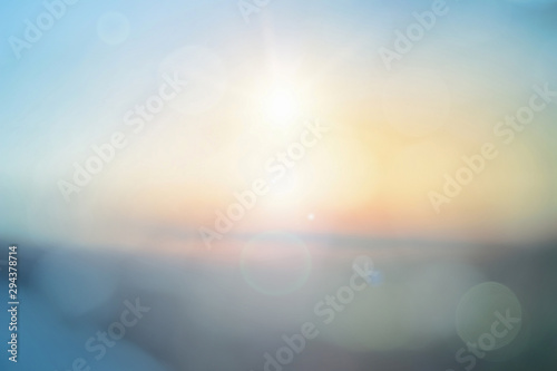 Natural background blurring warm colors and bright sun light. Bokeh or Christmas background Green Energy at sky sunny color orange light patterns plain abstract flare evening clouds blur.