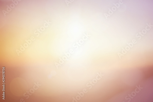 Natural background blurring warm colors and bright sun light. Bokeh or Christmas background Green Energy at sky sunny color orange light patterns plain abstract flare evening clouds blur. photo