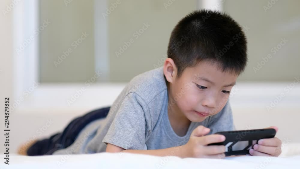 asian chinese boy playing smartphone on bed, kid use phone and play game, addicted game and cartoon, asian chinese boy playing smartphone on bed, kid use phone and play game, addicted game and cartoon,