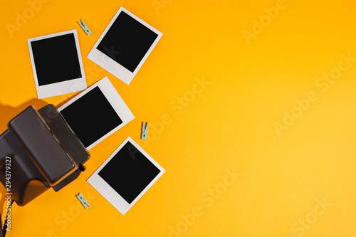Instant photo frames and camera on a yellow background. Concept of preservation of memories. Flat lay.